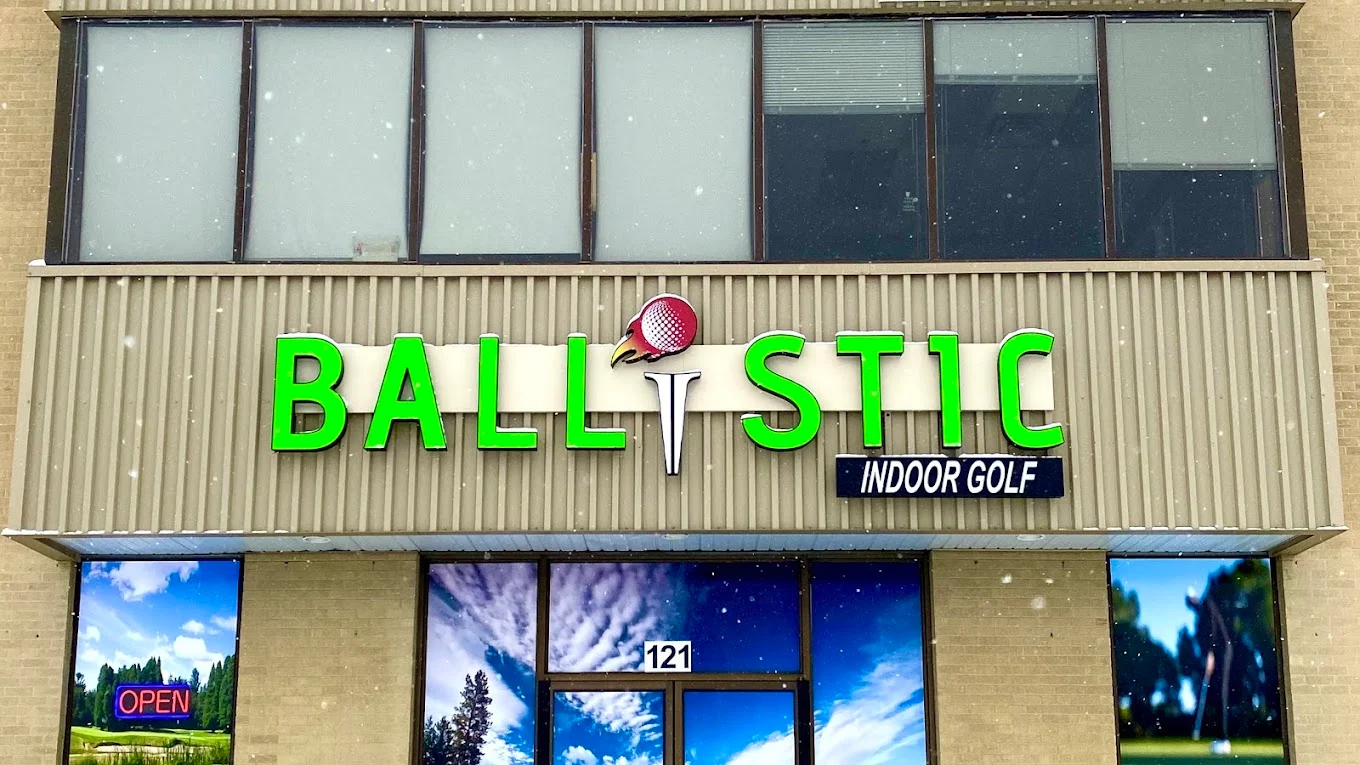 The Ballistic Indoor Golf storefront with its green sign and golf imagery