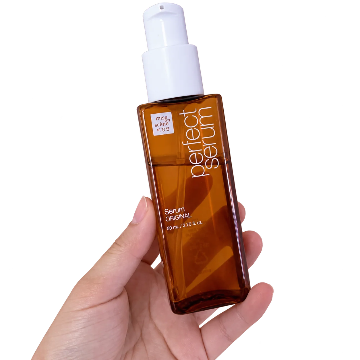 My hand holding an 80 mL bottle of mise en scène Perfect Serum Original.